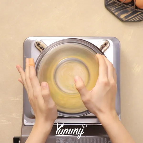 Tutup wadah dengan mangkuk tahan panas dan masak hingga beruap selama 15 menit, kemudian matikan kompor.