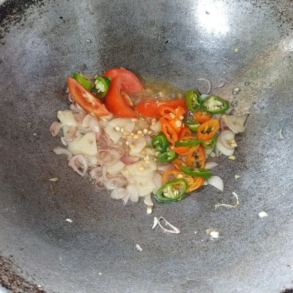 Tumis bawang merah dan bawang putih sampai harum.
Setelah harum masukkan cabai dan tomat, masak hingga layu.