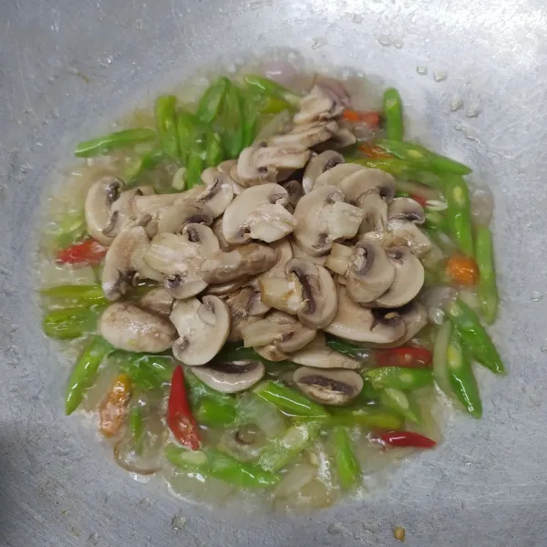 Masukkan irisan jamur kancing, aduk rata.