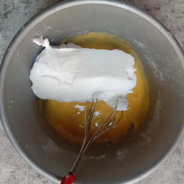 Masukan adonan putih telur ke dalam adonan kuning telur secara bertahap hingga 4x lakukan aduk balik.