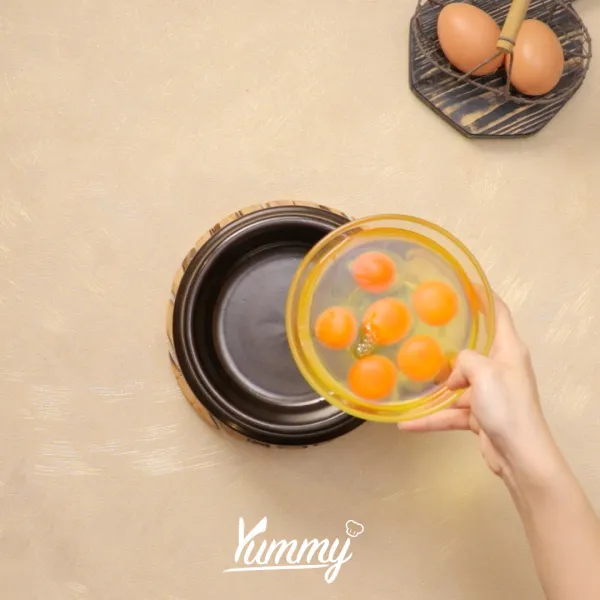 Pecahkan telur ke dalam wadah keramik atau ttukbaegi (mangkuk korea).