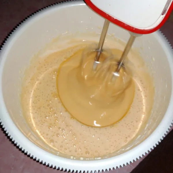 Tuang air gula karamel sambil dikocok dengan kecepatan rendah hingga tercampur rata.
