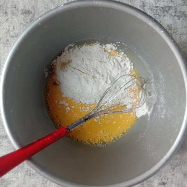 Tambahkan tepung dan vanila, aduk rata kembali.
