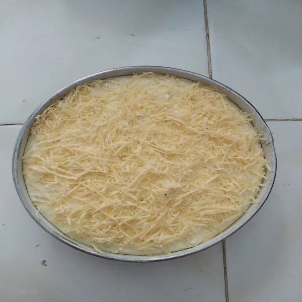 Tuang ke dalam loyang yang sudah diolesi dengan margarin dan taburan tepung, lalu beri topping di atasnya.
Panggang dengan suhu 180°C hingga matang.
