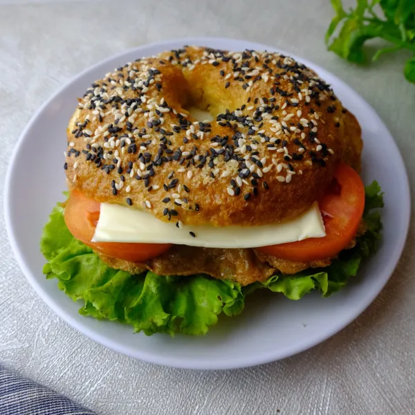 Belah dua bagelnya, lalu isi dengan isiannya. Lebih yummy kalau dihangatkan dulu di microwave sebelum disajikan.