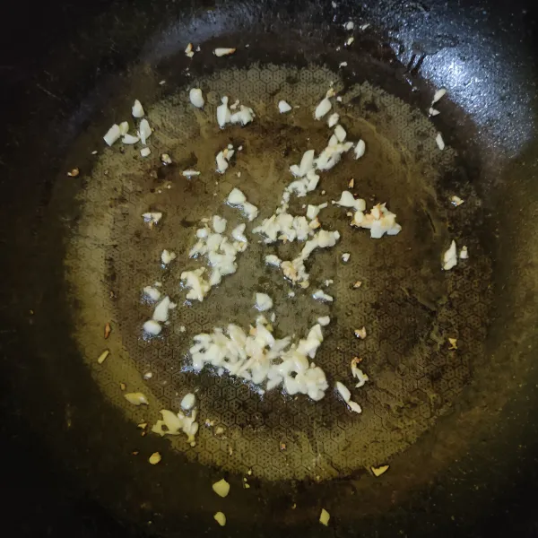 Tumis bawang putih cincang hingga harum dan matang.