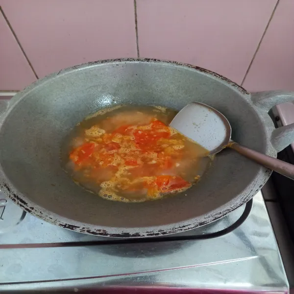 Masukan tomat, tekan-tekan dan masak hingga layu dan tambahkan air, masak sampai tomat hancur.