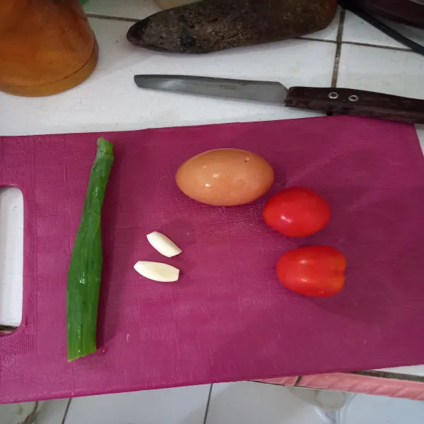 Siapkan bahan-bahan, cuci bersih tomat, telur dan daun bawang, kupas kulit bawang putih.