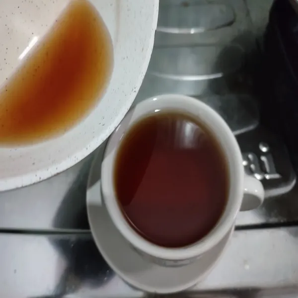 Tuang air rebusan teh ke dalam gelas saji, kemudian beri gula pasir, aduk rata.