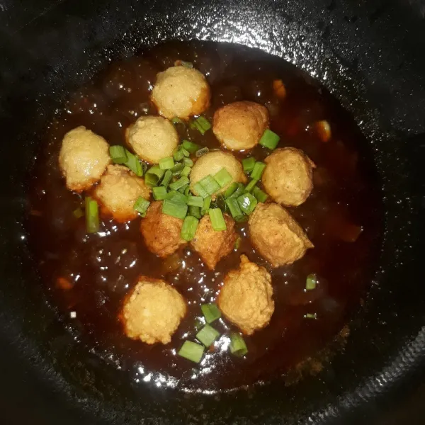 Masukkan bola ayam dan daun bawang, aduk sebentar sampai daun bawang layu. Angkat lalu sajikan dengan bahan pelengkap.