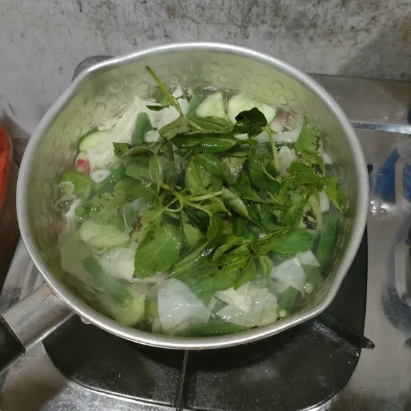 Sebelum diangkat, tambahkan daun kemangi, aduk sebentar.