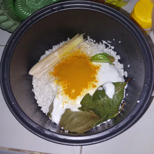 Campurkan semua bahan nasi kuning rice cooker. Beri air kemudian aduk rata.