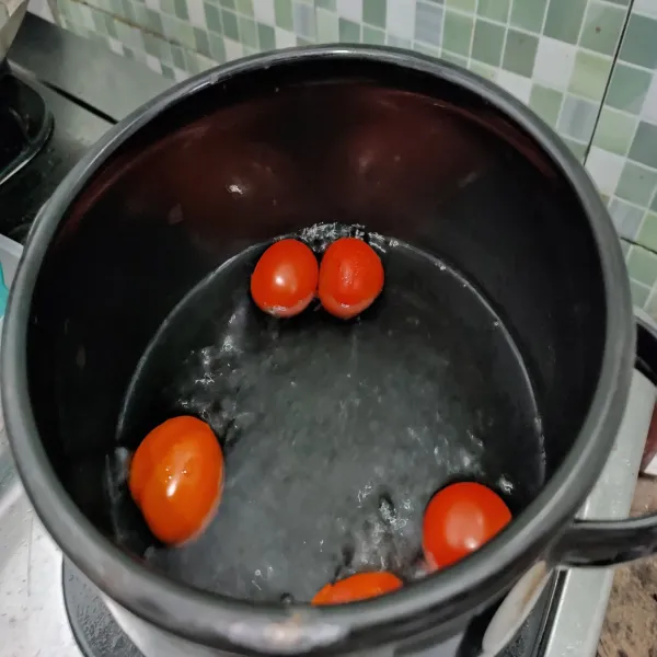 Rebus tomat kira-kira selama 5 menit sampai kulitnya mulai retak.
Kemudian matikan api.