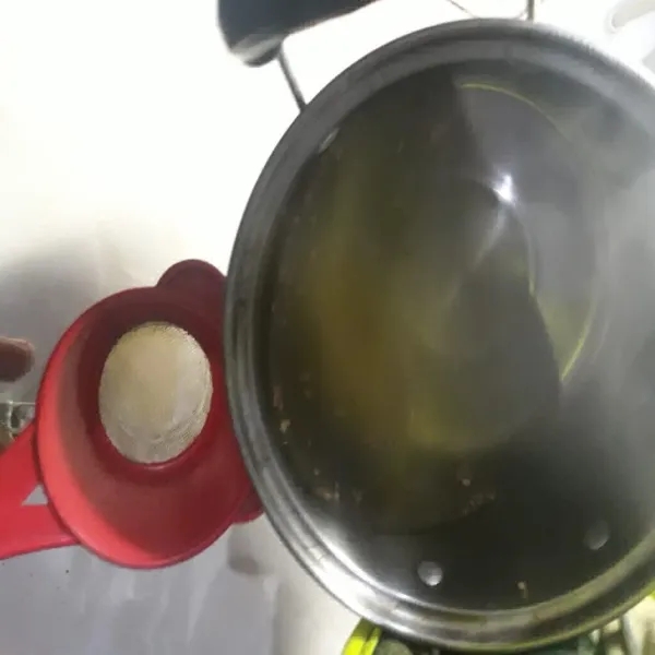 Tuang air rebusan jahe ke dalam gelas.