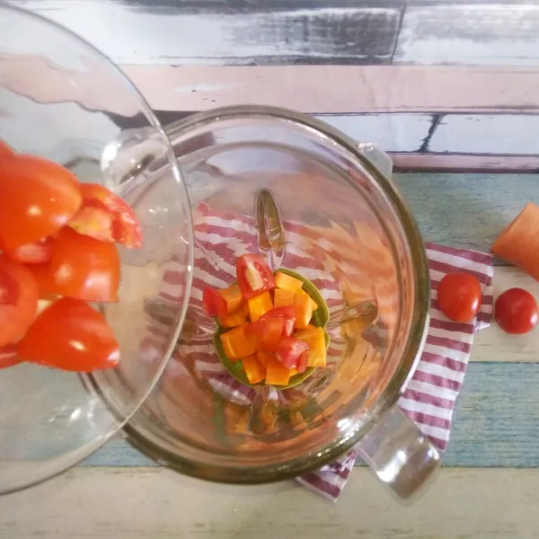 Siapkan blender, masukkan wortel dan tomat ke dalamnya.