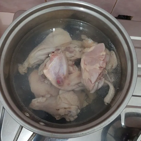 Rebus ayam hingga setengah matang, lalu tiriskan.