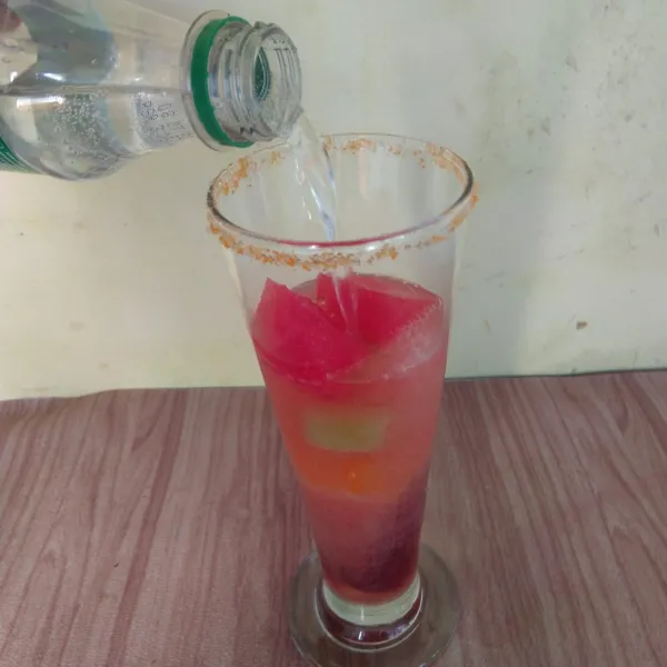 Tambahkan air soda hingga gelas penuh, sajikan.