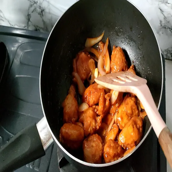 Masukkan tahu yang sudah digoreng tadi, aduk sampai semua tahu terbalut saus, angkat dan siap di hidangkan.