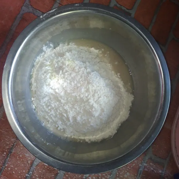 Masukkan tepung terigu dan garam ke dalam campuran ragi dan air, aduk sebentar.