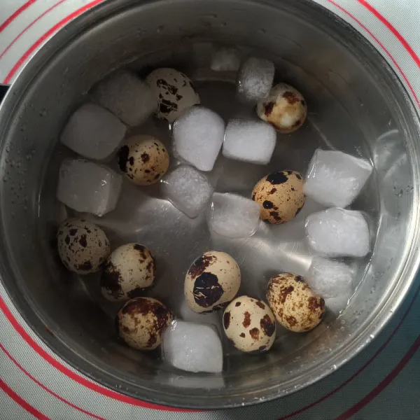 Rebus telur puyuh selama 2 menit, angkat dan langsung masukkan ke air es. Biarkan sampai dingin lalu kupas hati-hati.