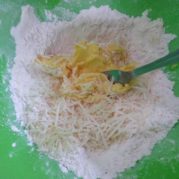 Campur terigu, margarin dan keju, aduk menggunakan garpu.