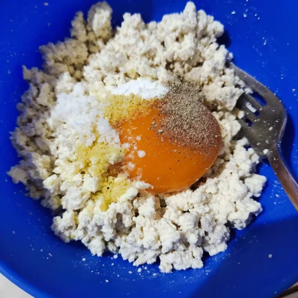 Masukkan kuning telur, garam, kaldu bubuk, merica bubuk, dan baking powder. Lalu aduk hingga tercampur merata.