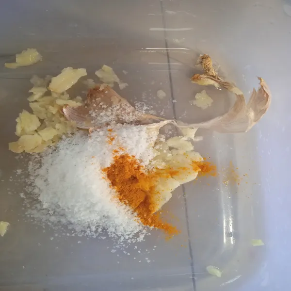 Geprek bawang putih, tambahkan garam dan kunyit bubuk.
