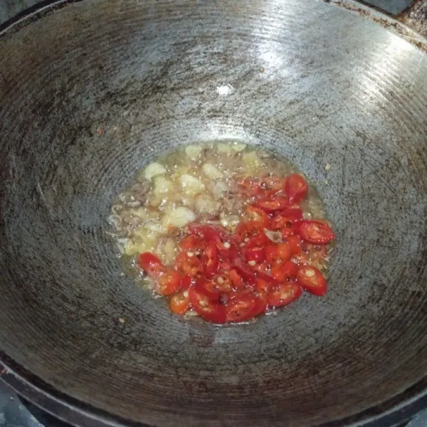 Panaskan minyak, lalu tumis bawang merah dan bawang putih. Setelah harum masukkan cabai merah, lalu aduk rata.