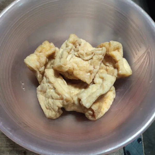 Potong tahu sesuai selera.
Panaskan minyak lalu goreng tahu sampai matang dan kering.