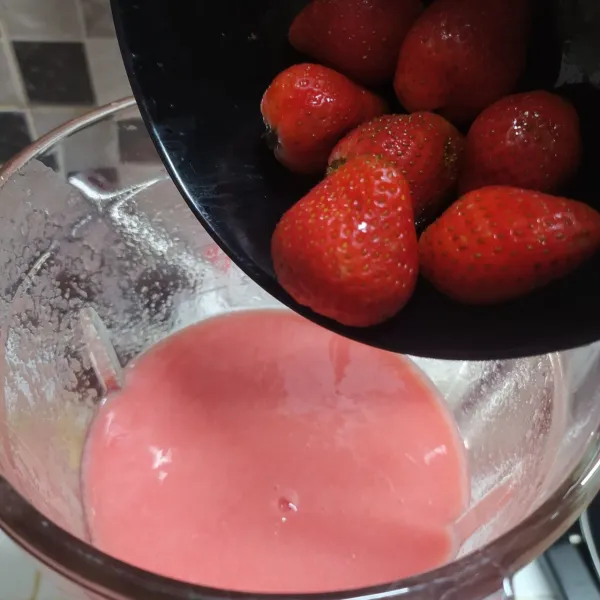 Masukkan jus jambu dalam blender kembali. 
Tambahkan strawberry dalam blender.