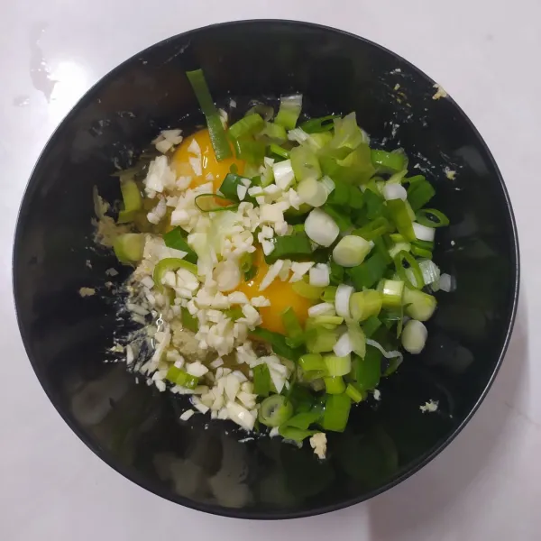 Tambahkan bawang putih cincang dan daun bawang. 
Aduk sampai rata.