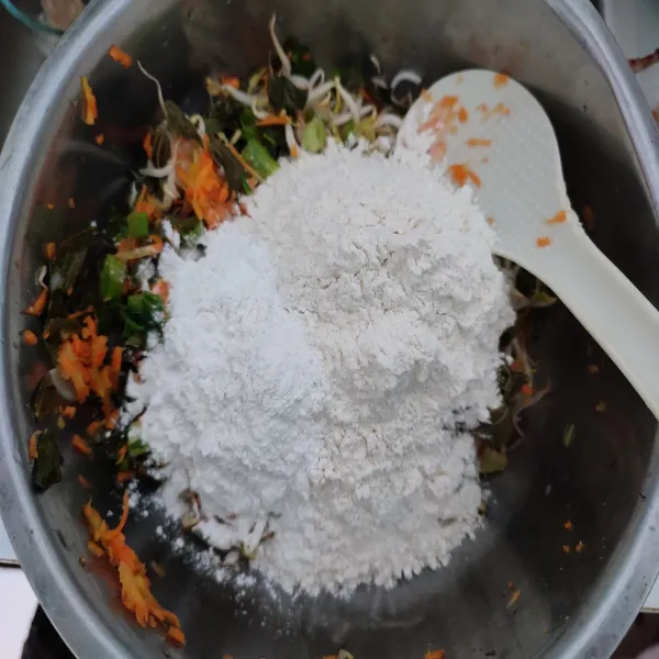 Kemudian masukkan tepung terigu dan tepung beras. 
Aduk rata.