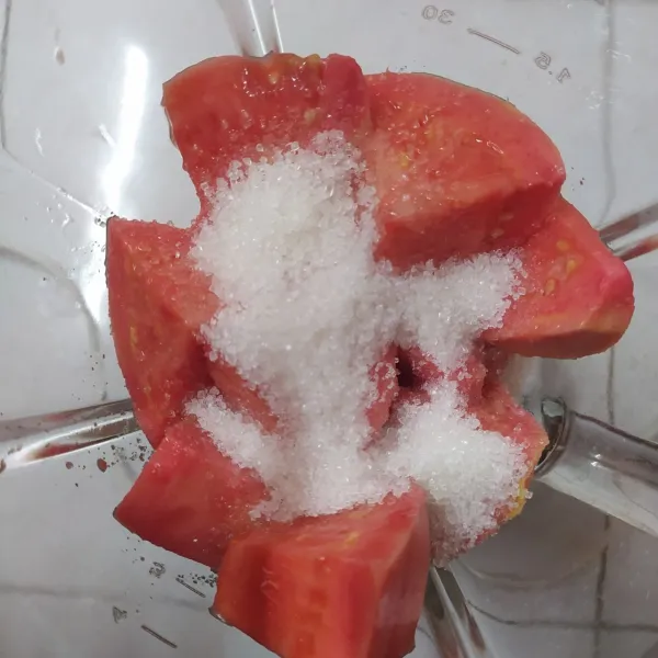 Masukkan jambu merah, gula pasir dan air matang dalam blender.