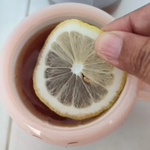 Tambahkan irisan lemon, sebisa mungkin buang bijinya supaya tidak pahit. 
Sajikan selagi hangat.