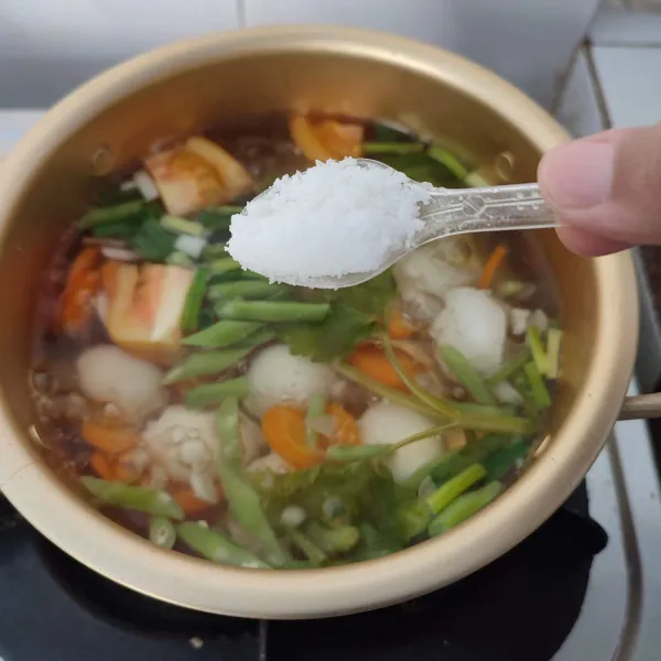 Ketika air mendidih, bumbui dengan garam, gula, merica bubuk dan kaldu jamur.
Koreksi rasa, matikan kompor ketika bumbu sudah meresap.