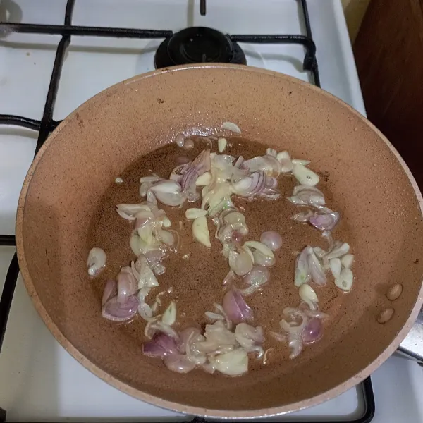 Tumis irisan bawang putih dan bawang merah hingga harum.