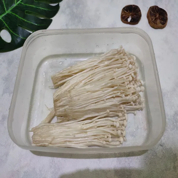 Potong bagian akar jamur enoki, kemudian cuci bersih, sisihkan. 
Lalu bagi menjadi beberapa bagian.