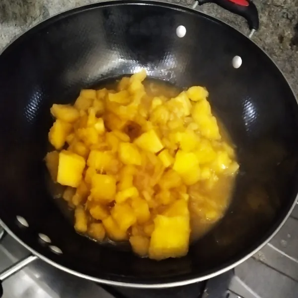 Masukkan singkong ke dalam gula merah cair, masak sampai air susut dan kental.