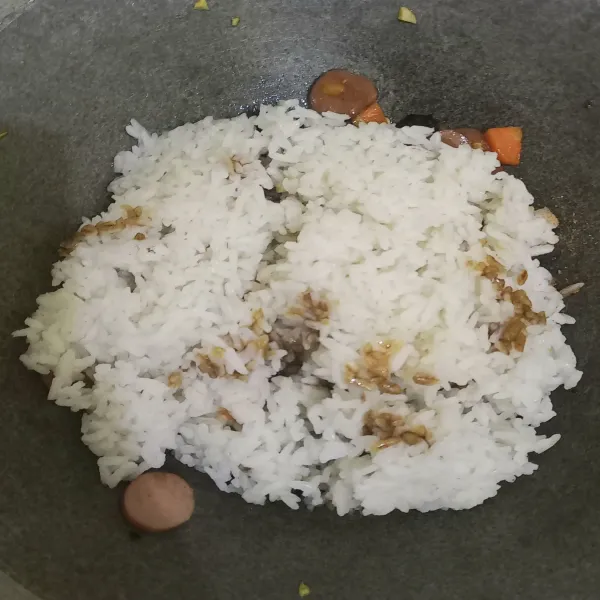 Masukkan nasi tambahkan garam, penyedap rasa, dan kecap.