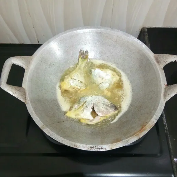 Kemudian goreng ikan dalam minyak panas hingga matang di kedua sisinya. Angkat dan tiriskan.