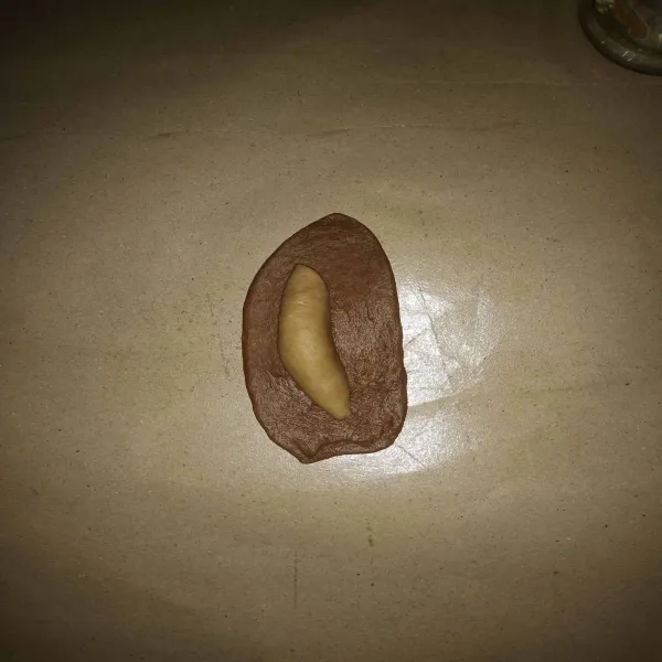 Ambil salah satu adonan warna cokelat muda, gilas hingga pipih lalu gulung, lakukan hal yang sama sampai semua adonan cokelat muda selesai dibentuk. 
Ambil salah satu adonan cokelat tua, gilas hingga pipih, tata adonan cokelat muda di atasnya lalu tutup rapat, lakukan hal yang sama hingga tuntas.