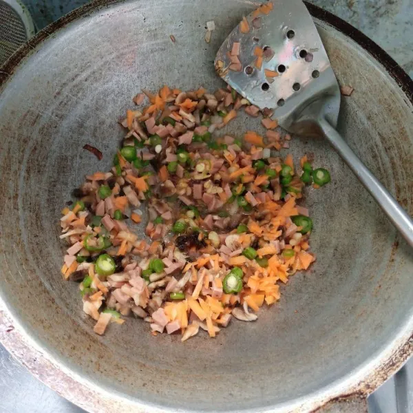 Masukkan wortel, buncis, sosis dan jamur kancing. Aduk rata. Masak sampai layu.