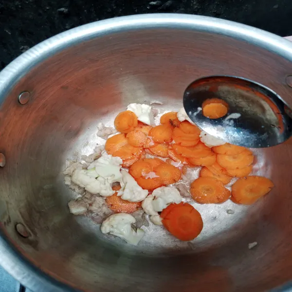 Masukkan wortel dan bunga kol terlebih dahulu tambah kan air hingga setengah matang.