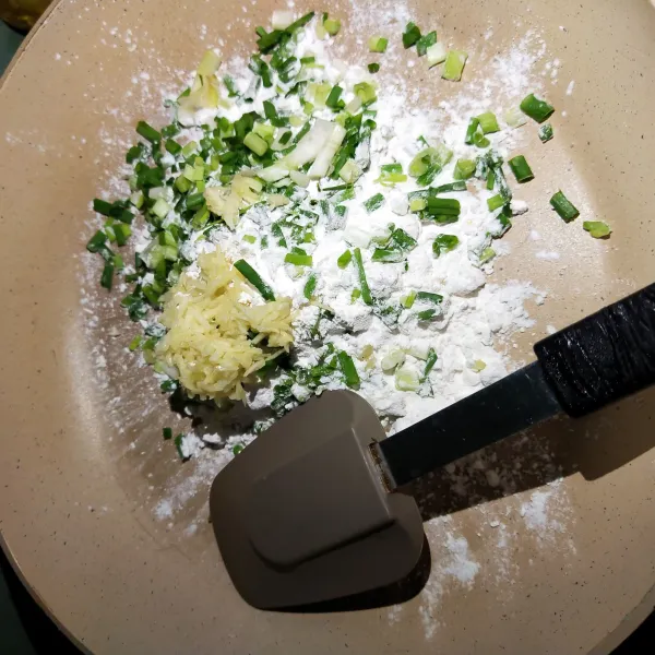 Langkah yang pertama masukkan tepung tapioka dan bawang putih yang sudah diparut irisan daun bawang, garam dan penyedap rasa.