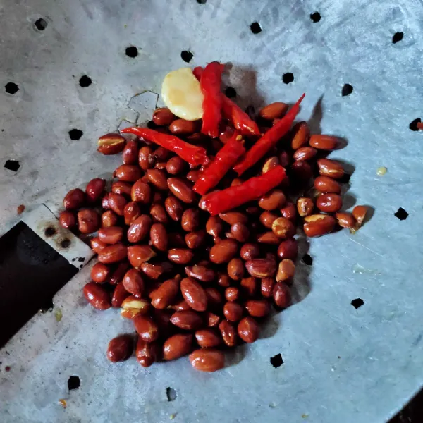 Goreng kacang terlebih dahulu, angkat, lalu goreng cabe dan bawang putih jangan terlalu kering, angkat.