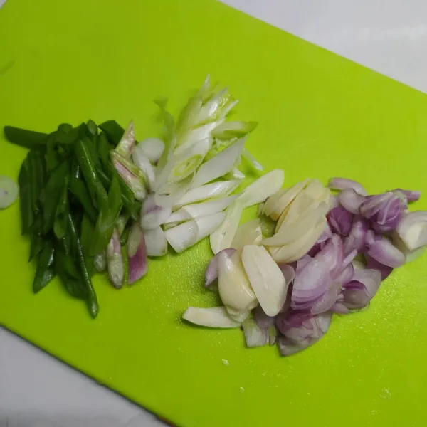 Potong serong daun bawang. 
Iris tipis bawang merah dan bawang putih.