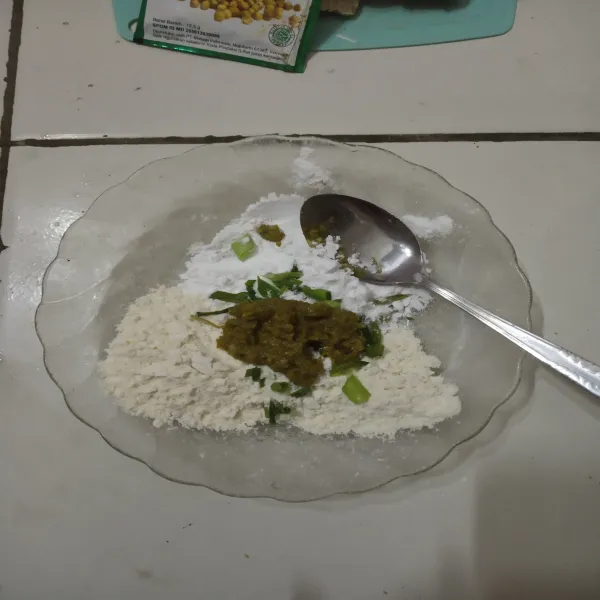 Siapkan piring, masukkan tepung terigu dan tepung tapioka. 
Kemudian beri daun bawang dan bumbu.