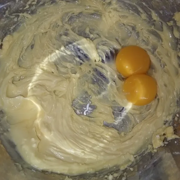 Masukkan gula, mentega dan butter mixer cukup rata, tuang kuning telur.