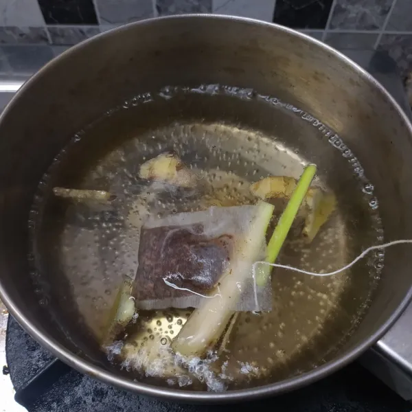 Setelah panas masukkan serai dan teh celup. 
Rebus sampai mendidih dan berubah warna.