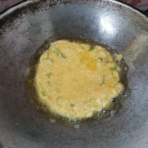 Panaskan minyak goreng secukupnya, lalu tuang telur. Kemudian goreng hingga bagian bawah matang.